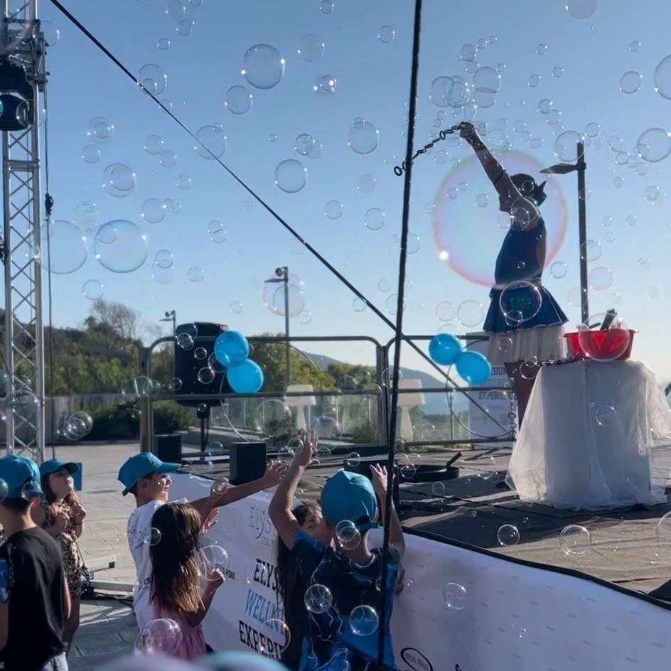 Artista fa grandi bolle di sapone davanti a un gruppo di bambini