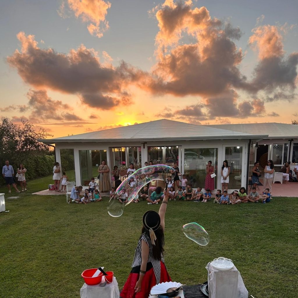 Bolle di sapone giganti al tramonto durante una festa in giardino