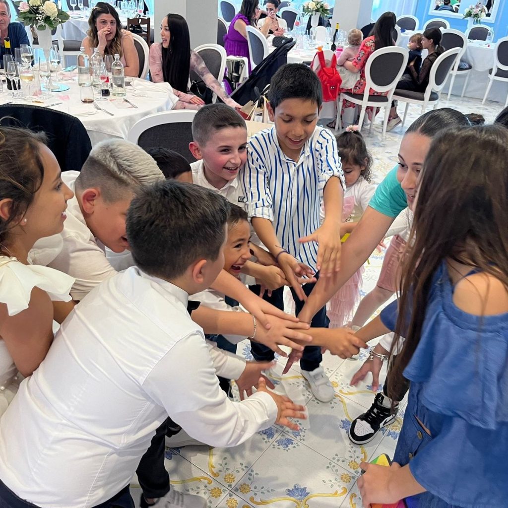 Bambini in cerchio attorno al tavolo durante il gioco di una cerimonia