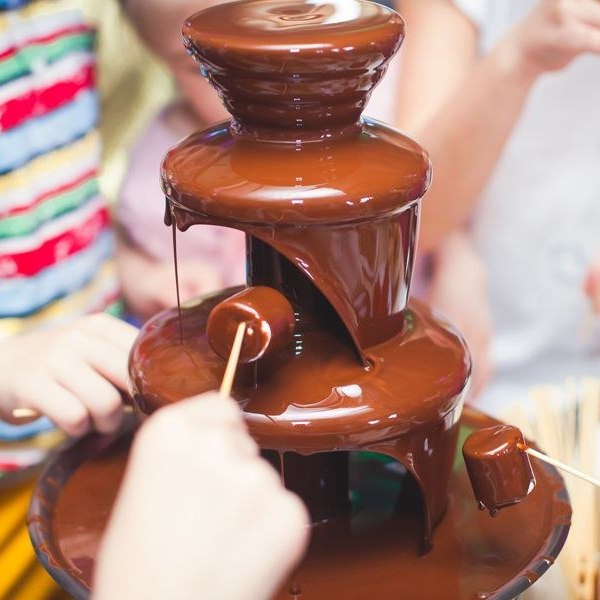 Fontana di cioccolato con la frutta da intingere a un compleanno