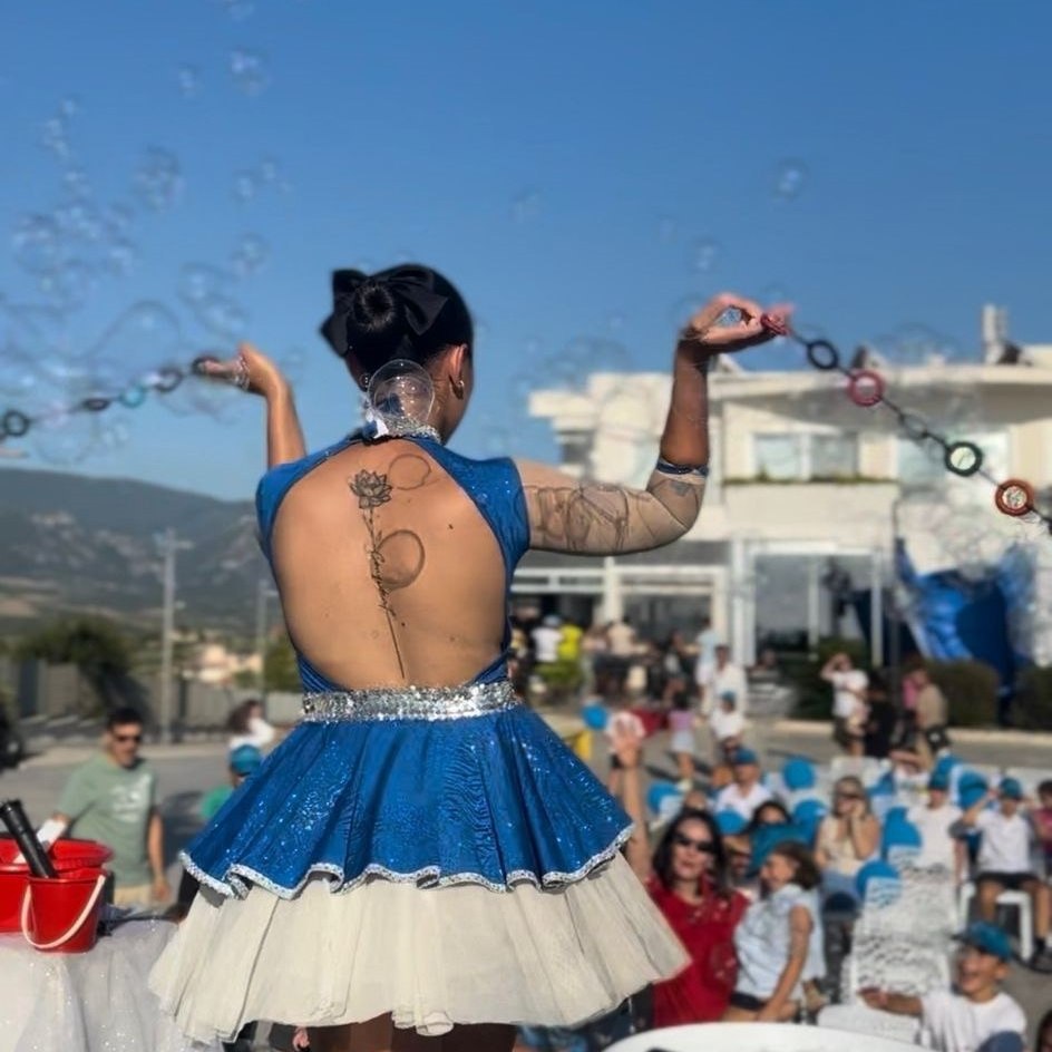 Artista di bolle di sapone di spalle davanti al pubblico