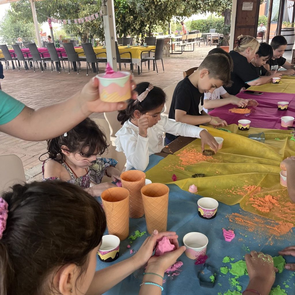 Bambini al laboratorio creativo con colori e bicchieri
