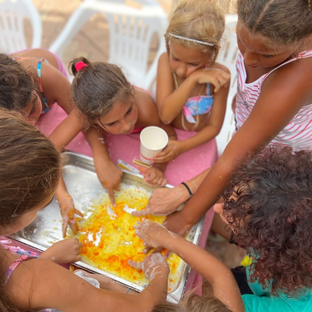 Bambine attorno al vassoio durante il laboratorio dello slime
