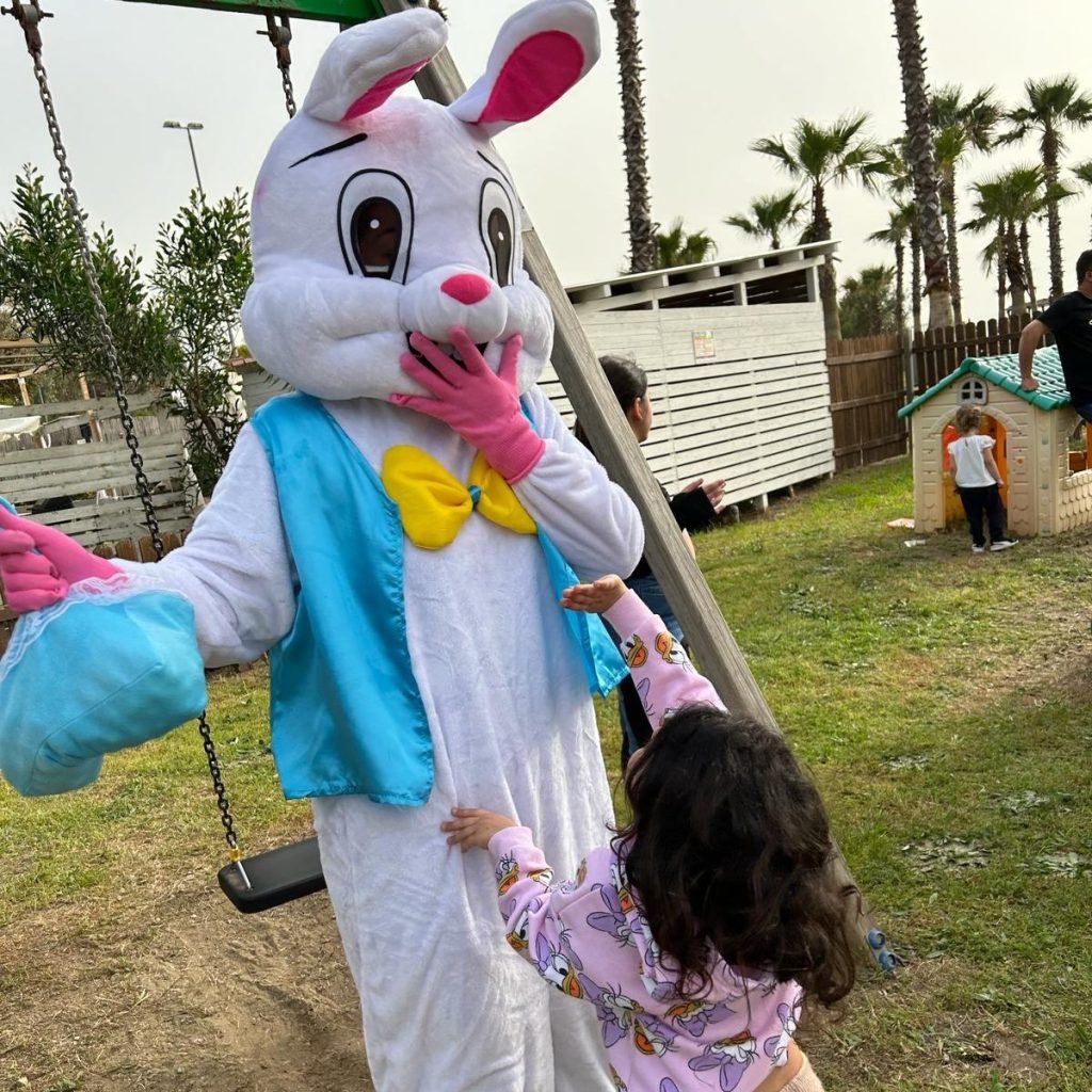 Mascotte a forma di coniglio saluta una bambina
